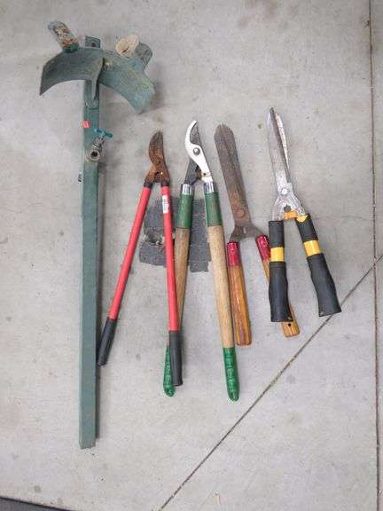 Two loppers, two shears, and a hose bib on a metal pole