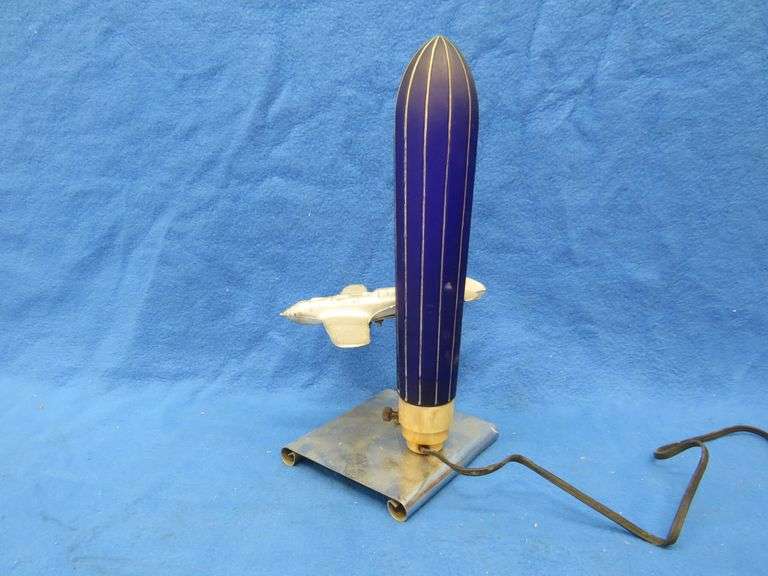 Art Deco era table lamp depicting an airplane in flight.  Cobalt blue glass shade