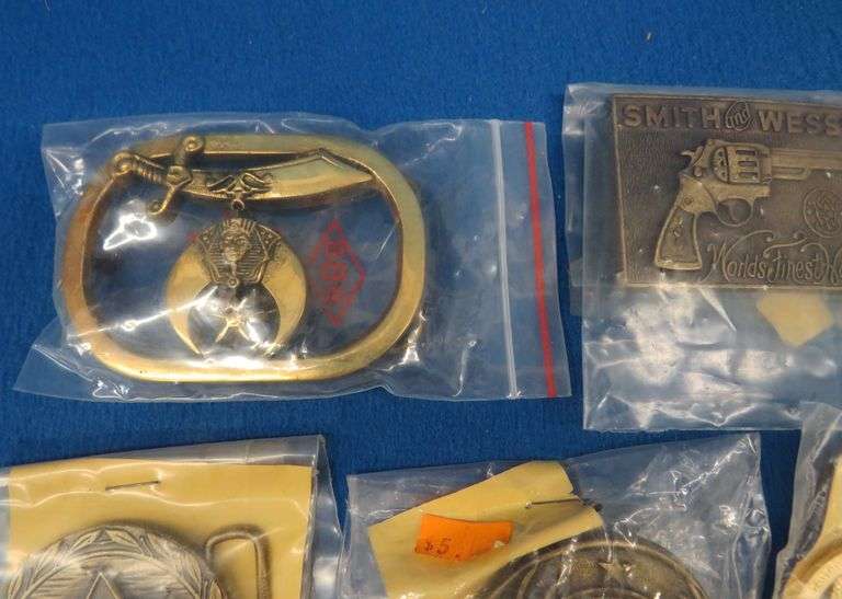 Eight belt buckles from fraternal organizations and one from Smith and Wesson. Some are marked as br