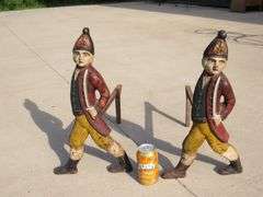 Two matching Hessian soldier antique cast iron andirons