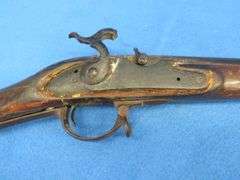 Antique black powder rifle.  Unknown maker or caliber.  Not safe to shoot.  Non-operable hammer and 