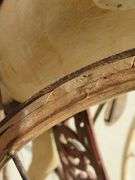 Antique wooden horse tricycle with a cast iron frame, hand-painted details, leather saddle, and wood