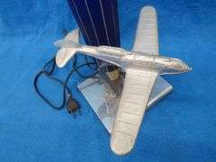 Art Deco era table lamp depicting an airplane in flight.  Cobalt blue glass shade