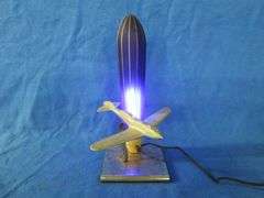 Art Deco era table lamp depicting an airplane in flight.  Cobalt blue glass shade
