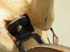 Antique wooden horse tricycle with a cast iron frame, hand-painted details, leather saddle, and wood