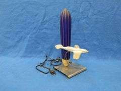 Art Deco era table lamp depicting an airplane in flight.  Cobalt blue glass shade