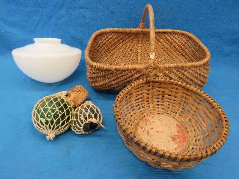 Two wicker baskets, a glass shade, and glass ball fishing floats.