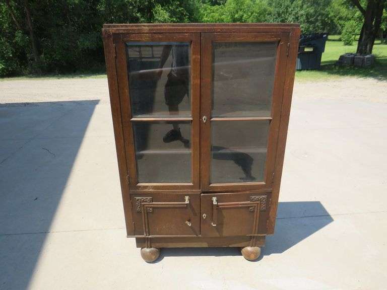 Two door free standing bookcase with beveled glass and lower storage area.  56" x 36" x 11"
