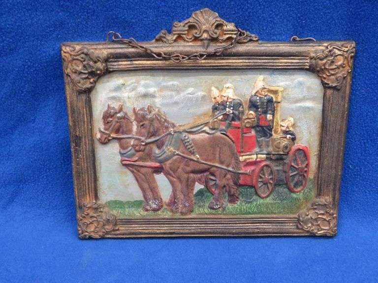Cast iron plaque showing a horse-drawn fire engine with no markings