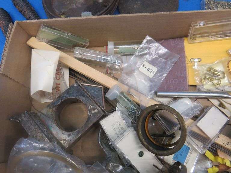Clock parts including weights, extremely small screws, and more.