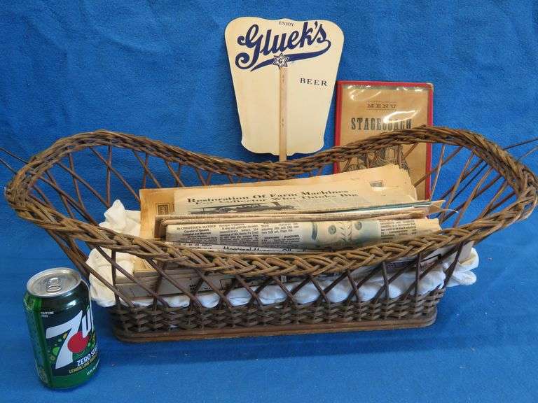 Antique wicker basket with an old Gluek's advertising fan, and Collector's Weekly and Antique monthl