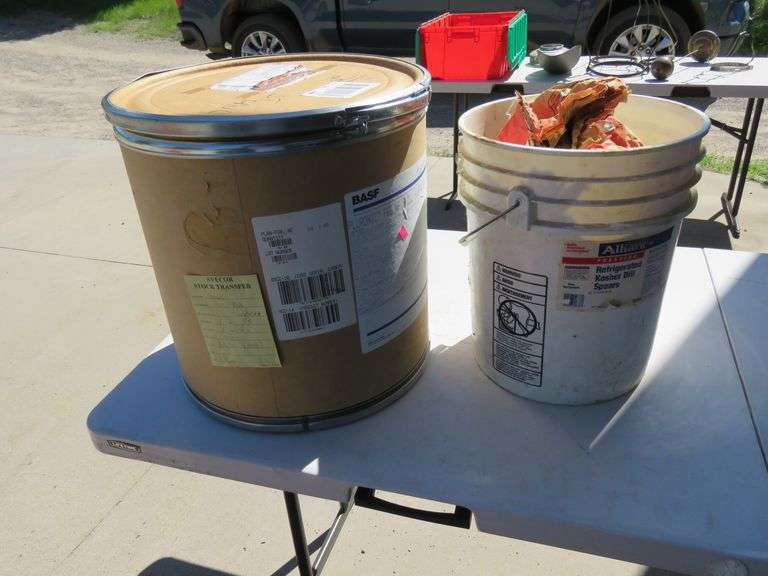 One-half a bag of charcoal in a bucket and a covered cardboard barrel