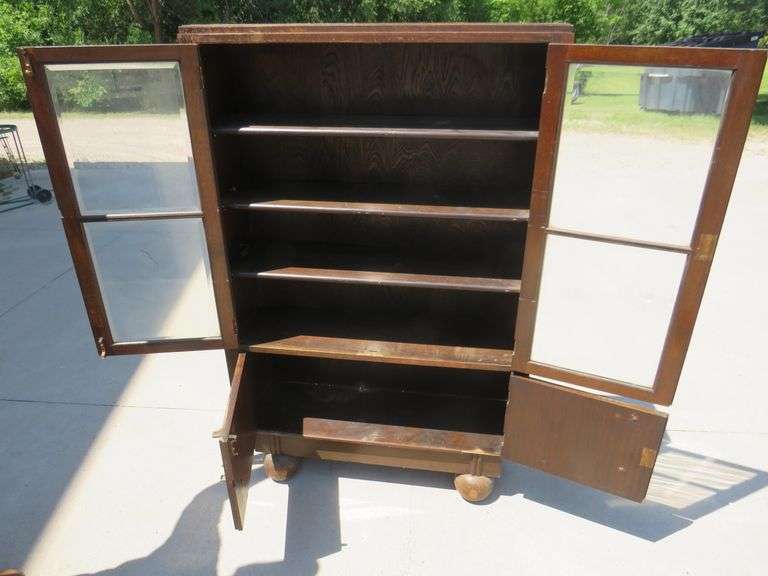 Two door free standing bookcase with beveled glass and lower storage area.  56" x 36" x 11"
