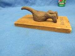 Cast iron south end of a dog going north on a wooden plaque