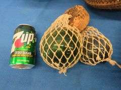 Two wicker baskets, a glass shade, and glass ball fishing floats.