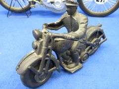 Two vintage cast iron motorcycles, one with rubber tires, and a metal Harley-Davidson