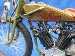 Two vintage cast iron motorcycles, one with rubber tires, and a metal Harley-Davidson