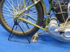 Two vintage cast iron motorcycles, one with rubber tires, and a metal Harley-Davidson