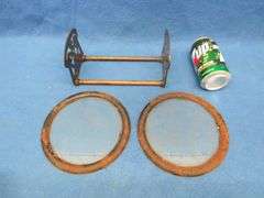 Two 7" round windows in metal frames and an adjustable metal book rack