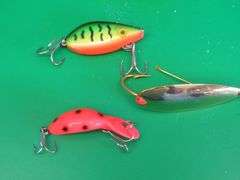 Three vintage baits all in boxes. Heddon Tiny Tad, Storm Lil Tex, and Johnson's Gold Minnow