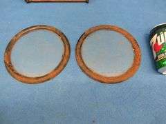 Two 7" round windows in metal frames and an adjustable metal book rack