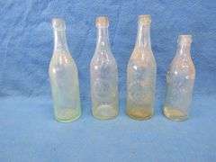 Four old beer bottles from Jac. Schmidt, Gluek, C. Birkhofer, and Jacob Ries