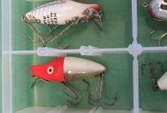 Eight Heddon Baits and a bait box, including River Runts, Midget Digits, and a Torpedo-style bait fr