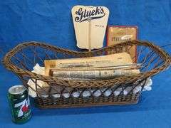 Antique wicker basket with an old Gluek's advertising fan, and Collector's Weekly and Antique monthl