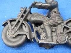 Two vintage cast iron motorcycles, one with rubber tires, and a metal Harley-Davidson