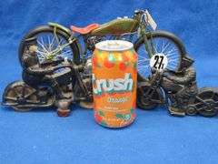 Two vintage cast iron motorcycles, one with rubber tires, and a metal Harley-Davidson