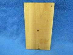 Cast iron south end of a dog going north on a wooden plaque