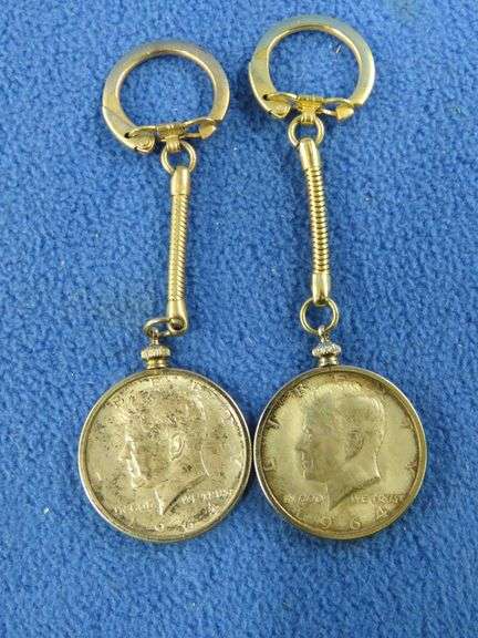 Two silver 1964 Kennedy half-dollars in bezels