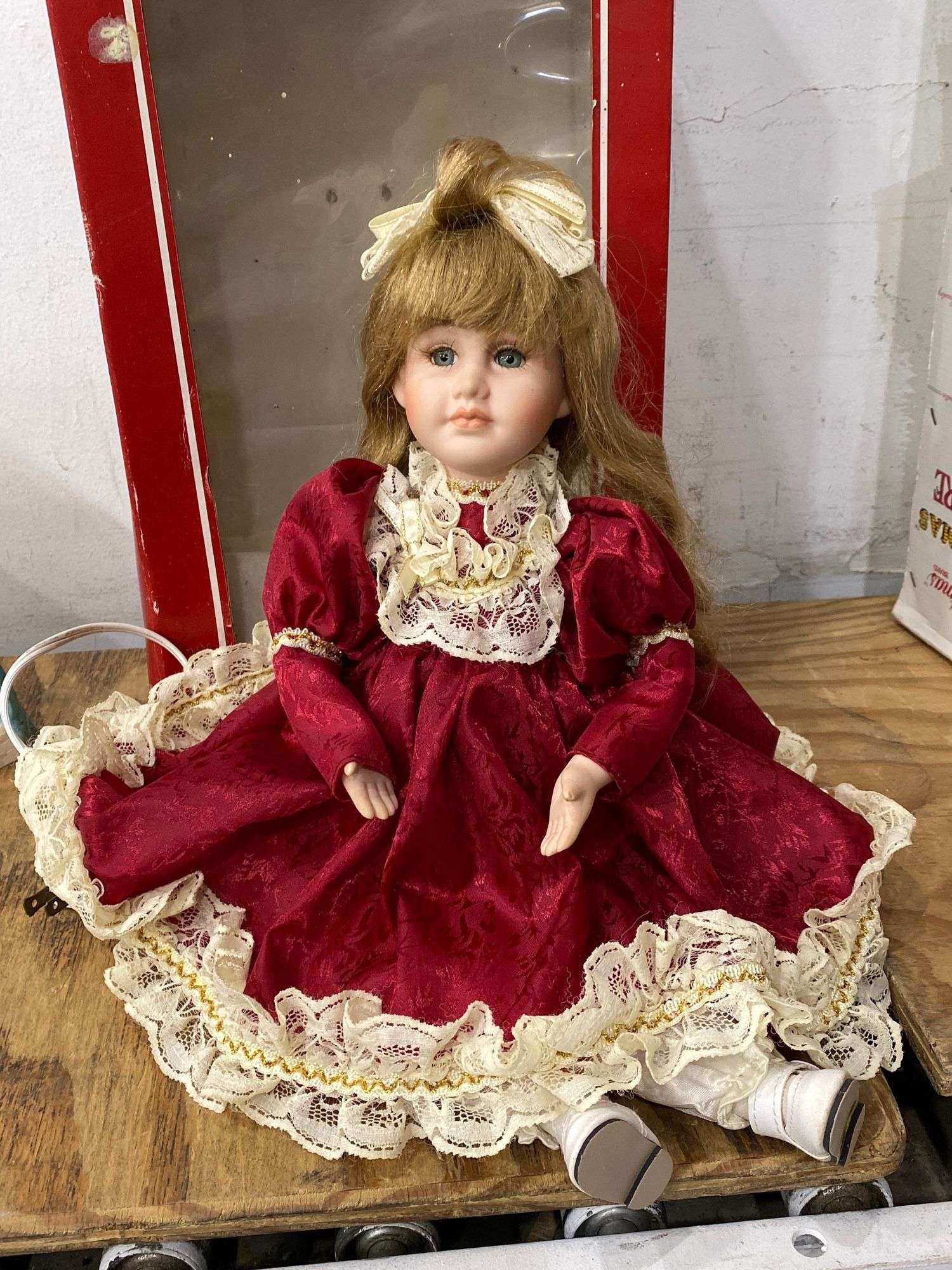 porcelain doll red dress Porcelain doll With Red Dress, On a wooden
