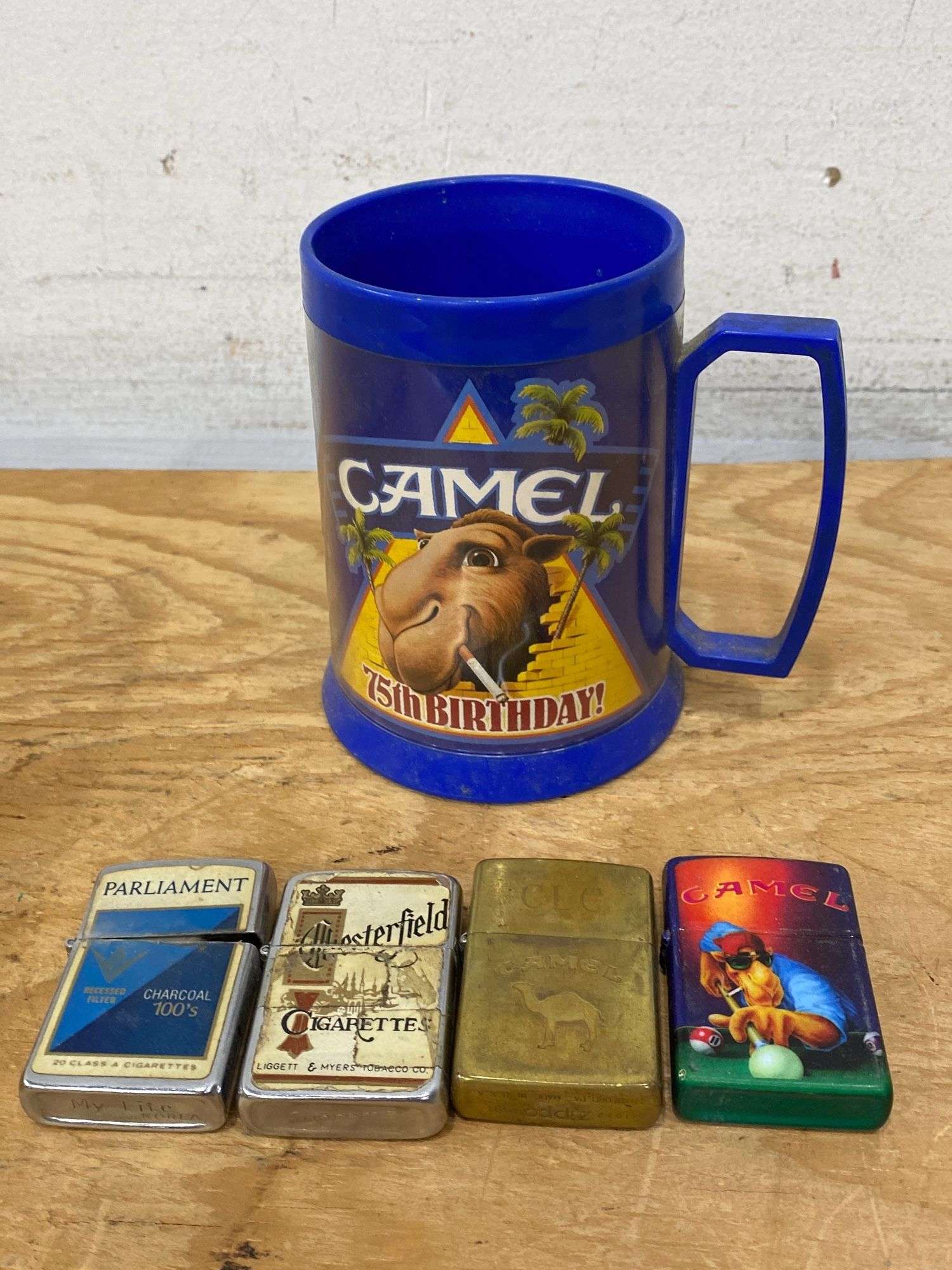 Vintage cigarette branded lighters (2 are Zippo), Camel plastic mug. 8d -  Lil Dusty Online Auctions