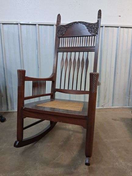Intricate wood rocking chair with caned seat