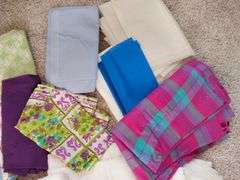 Large box of sewing material. Bolts of cloth. Curtains.