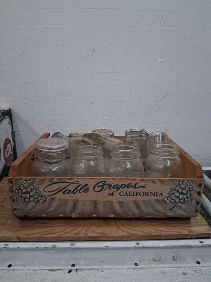 Vintage wooden CA grapes crate full of a variety of glass jars. 1e