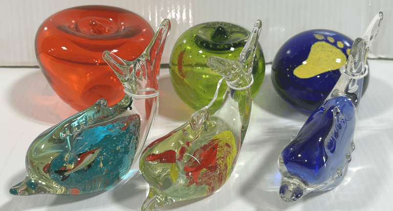 (6) Art glass paperweights, include: Rossini green art glass apple paperweight, Cobalt blue footprint in the sand paperweight, red glass apple paperweight, and 2- porpoise paperweights, excellent