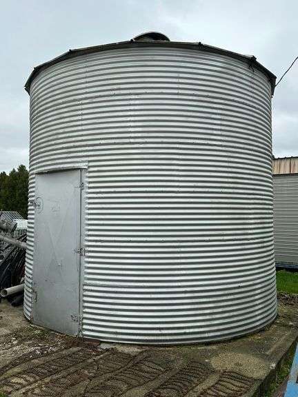 *Grain Bin with Auger, 13' diameter x 12' high to Top Ring.  *NOTE:  It is the buyer's responsibility to safely disassemble and load out this item by appointment following the regular checkout - No work will be allowed until after the scheduled checkout days.  No help will be provided.  The buyer will have from Saturday, May 6th until Sunday, June 21st to have it completely removed.