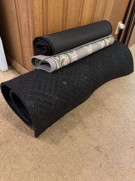 Three Rolled Floor Mats Including Plain Black and Patterned Designs