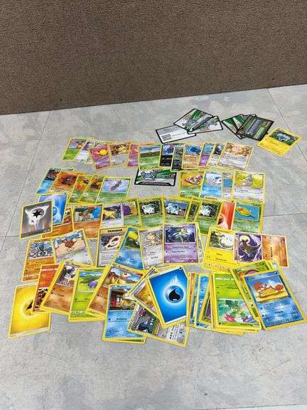 Over 50 Assorted Pokémon Cards Featuring Commons, Uncommons, Trainer, and Energy Cards with Online C