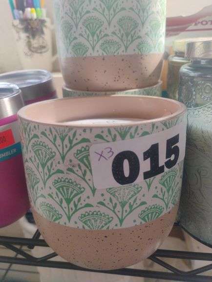 Speckled Ceramic Candle with Green Floral Pattern. A scented candle in a decorative ceramic vessel featuring a green block-print floral pattern and a speckled base. - $15 - 25