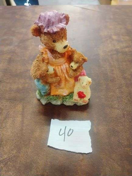 Collectible Resin Mother Bear and Cubs Family Figurine. This decorative resin figurine features a mother bear in a bonnet and apron holding two cubs, with another small cub holding a heart at her feet, all on a grassy base. - $18.00