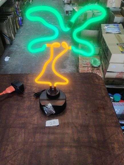 LED Neon Palm Tree Table Lamp. This decorative table lamp features a vibrant green and orange LED neon palm tree design on a dark base, perfect for ambient lighting or room decor. - $25.00