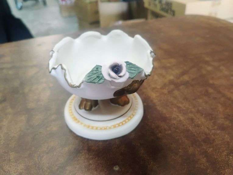 White Ceramic Footed Trinket Dish with Rose and Gold Trim. This is a small ceramic bowl with a ruffled edge, gold accents, and a delicate pink rose and green leaf embellishment, designed for decorative use or holding small items. - $20.00