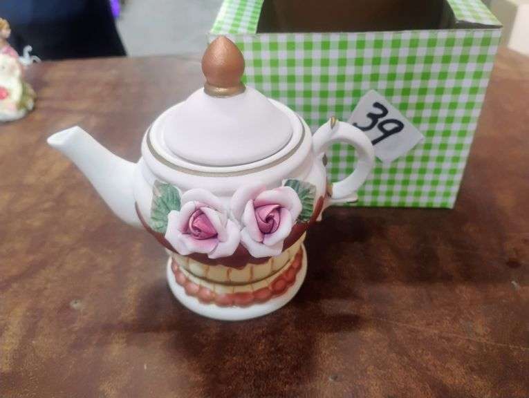 Decorative Porcelain Miniature Rose Teapot. This is a white porcelain decorative miniature teapot adorned with applied pink rose details, green leaves, and gold accents, featuring a small spout and handle. - $39.00