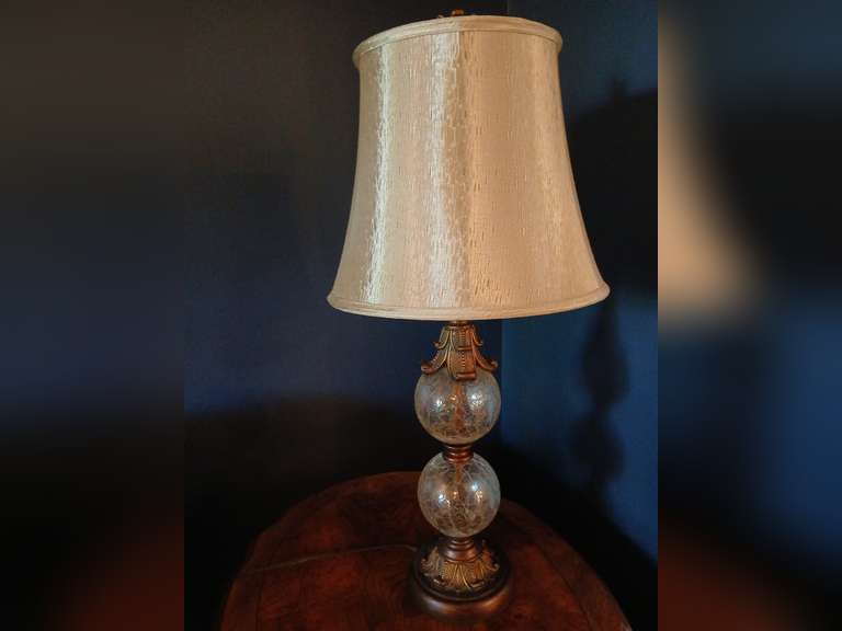 Ornate double globe distressed design brushed metal table lamp with cream shade. 29"h