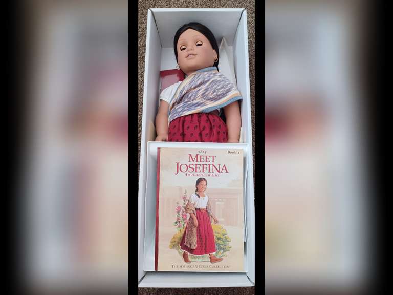 Josefina Montoya. Josefina is an original American Girl Doll. She stands 18inches and wears her original period clothing. Her time-period is 1824 Colonial New Mexico. Josefina has been maintained exclusively for display behind glass in a smoke-free environment, and she has not been used for play.
Josefina comes complete with her accessories and book, “Meet Josefina”, in the original box. Her doll stand is in a separate box.