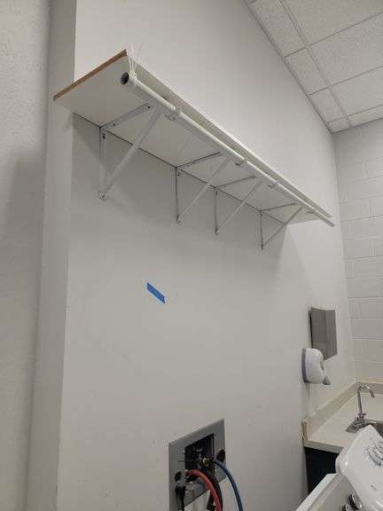 White shelf with soap dispenser and paper towel dispenser