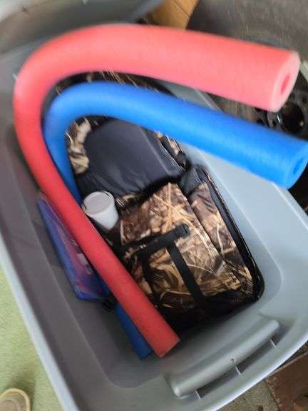 Tote with life vest, noodles and maps.